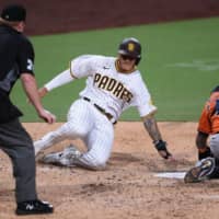 Padres third baseman Manny Machado (center) slides home safely ahead of the tag by Astros catcher Martin Maldonado (right) during the fifth inning on Friday in San Diego. | USA TODAY / VIA REUTERS