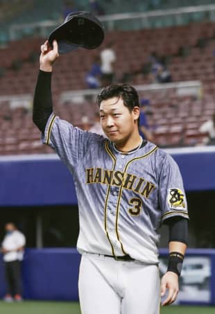 Tigers infielder Yusuke Oyama tips his cap to the crown after his teams win over the Dragons on Friday in Nagoya. | KYODO