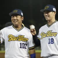 Buffaloes pitcher Yoshinobu Yamamoto poses with teammate Seiichiro Oshita after their win over the Eagles on Sept. 15 in Kobe. | KYODO