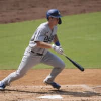 The Dodgers' Will Smith hits an RBI single against the Padres during the third inning on Wednesday in San Diego. | AP