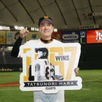 Giants manager Tatsunori Hara poses for photo after setting a club record with his 1,067th win on Friday at Tokyo Dome. | KYODO