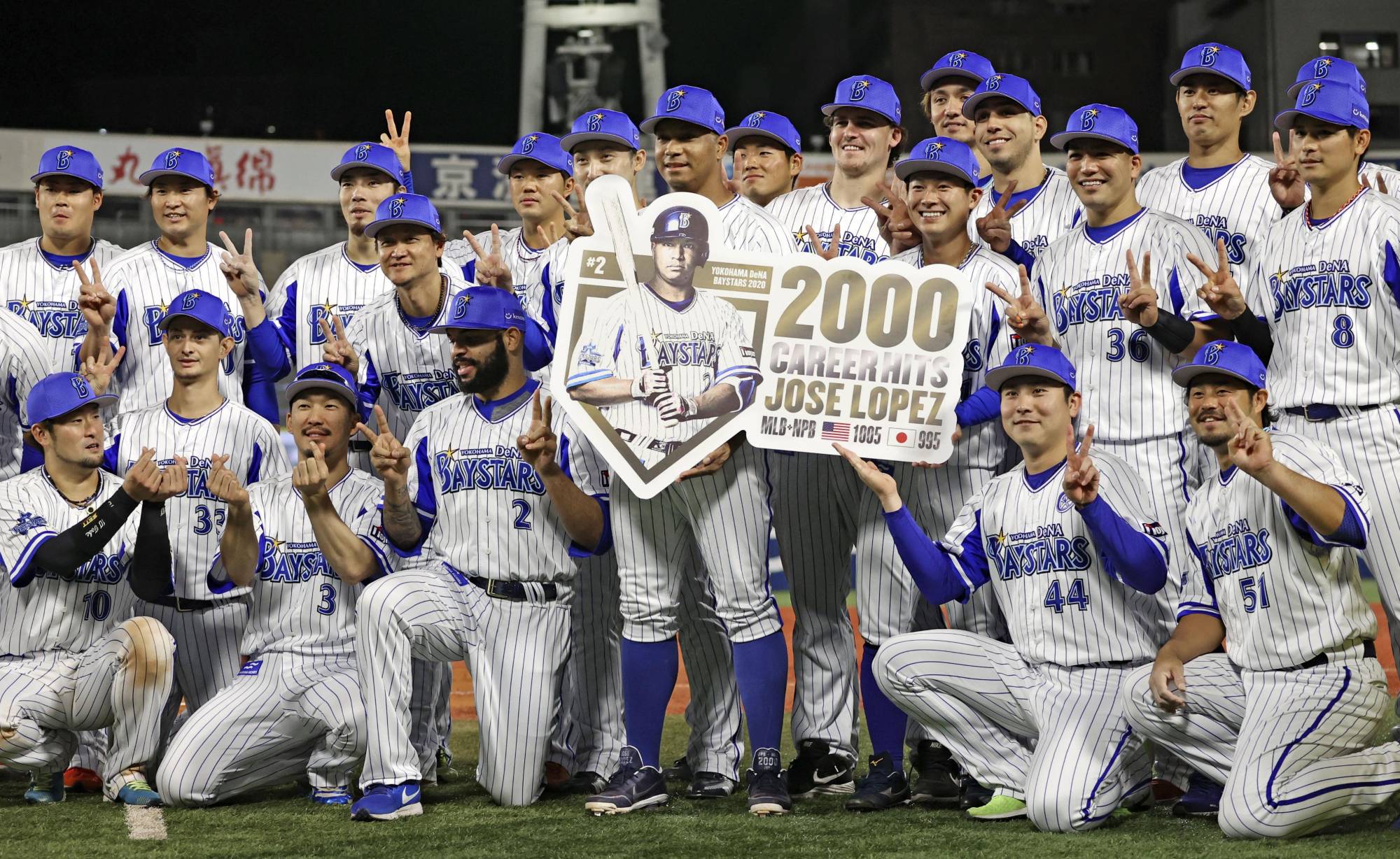 BayStars infielder Jose Lopez (center) celebrates with his teammates after reaching 2,000 combined hits between his career in MLB and NPB. | KYODO
