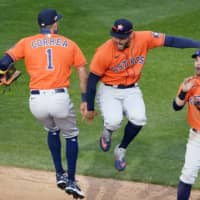 The Astros' Carlos Correra (left) and George Springer (center) celebrate after beating the Twins in Game 1 of their AL wild-card series in Minneapolis on Sept. 29. | AP