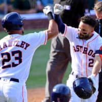 Astros second baseman Jose Altuve (right) is congratulated by teammate Michael Brantley after hitting a two-run home run against the Athletics on Thursday in Los Angeles. | USA TODAY / VIA REUTERS
