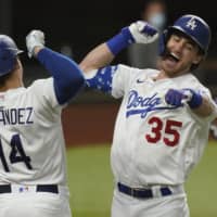 The Dodgers' Cody Bellinger (right) celebrates with teammate Enrique Hernandez after a solo homer against the Braves in the seventh inning of Game 7 in the NLCS. | AP