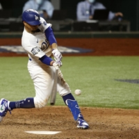 Dodgers outfielder Mookie Betts hits a single during the eighth inning in Game 1 of the World Series on Tuesday. | USA TODAY / VIA REUTERS
