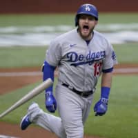 The Dodgers' Max Muncy celebrates after hitting a grand slam against the Braves during the first inning in Game 3 of the NLCS on Wednesday in Arlington, Texas. | AP