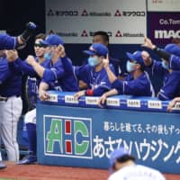 The Dragons' Takuya Kinoshita is congratulated by his teammates after hitting a three-run homer against the BayStars on Saturday in Yokohama. | KYODO
