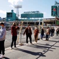 Voters wait to cast their ballots outside Fenway Park during the first day of early voting in Boston on Saturday. | REUTERS