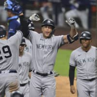 Yankees designated hitter Giancarlo Stanton (center) is congratulated by third baseman Gio Urshela (left) after hitting a grand slam against the Rays during Game 1 of the ALDS on Monday in San Diego. | USA TODAY / VIA REUTERS