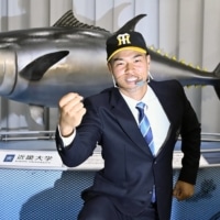 Kindai University infielder Teruaki Sato, whose negotiation rights were acquired by the Tigers during the NPB amateur draft, poses for photos on Tuesday in Higashiosaka, Osaka Prefecture. | KYODO