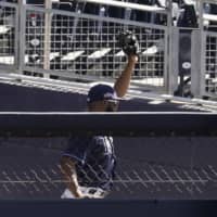 Right field umpire Manny Gonzalez (right) calls an out after Rays right fielder Manuel Margot fell over a right field wall while catching a foul ball by Astros center fielder George Springer during the second inning in Game 2 the American League Championship Series on Monday in San Diego. | AP