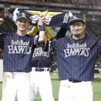 The Hawks' Ukyo Shuto (left) and Yuito Mori celebrate after their win over the Marines on Sunday in Fukuoka. | KYODO