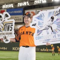 Tomoyuki Sugano poses for photos after recording the 100th victory of his career and his 13th straight since opening day this season on Oct. 6 at Tokyo Dome. | KYODO