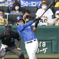The BayStars' Tyler Austin hits a home run against the Tigers during the fourth inning on Saturday. | KYODO