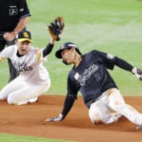 The Marines' Kyota Fujiwara (right) beats the tag by the Hawks' Hikaru Kawase during their game in Fukuoka on Friday. | KYODO
