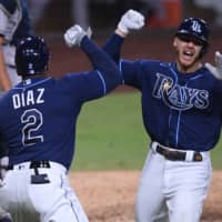 The Rays' Mike Brosseau celebrates with teammate Yandy Diaz after hitting a home run against the Yankees during the eighth inning in Game 5 of the ALDS on Friday in San Diego. | USA TODAY / VIA REUTERS