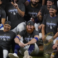 Justin Turner (center) poses for a group picture after the Dodgers' win over the Rays in Game 6 of the World Series on Tuesday in Arlington, Texas. | AP