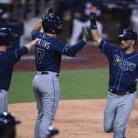 Rays center fielder Kevin Kiermaier (right) celebrates with right fielder Austin Meadows (center) and third baseman Joey Wendle after scoring a run against the Astros during Game 3 of the 2020 ALCS in San Diego on Tuesday. | USA TODAY / VIA REUTERS