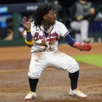 The Braves' Ronald Acuna Jr. celebrates after scoring against the Marlins in Game 1 of the NLDS on Tuesday in Houston. | AP