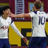 Tottenham striker Son Heung-Min (left) celebrates with teammate Harry Kane after scoring the opening goal against Burnley on Monday in Burnley, England. | POOL / VIA AFP-JIJI