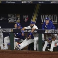 Members of the Dodgers watch during the seventh inning of Game 2 the World Series on Wednesday in Arlington, Texas. | AP