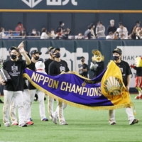 The Hawks carry the championship banner after winning the Japan Series on Wednesday. | KYODO