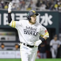 Hawks outfielder Yuki Yanagita tosses his bat after hitting a two-run home run against the Giants in the bottom of the first inning in Game 4 of the Japan Series on Wednesday at PayPay Dome in Fukuoka. | KYODO