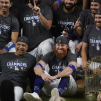 Justin Turner (center) poses for a team photo with the Dodgers after the team clinched the World Series in Arlington, Texas, on Oct. 27. | AP