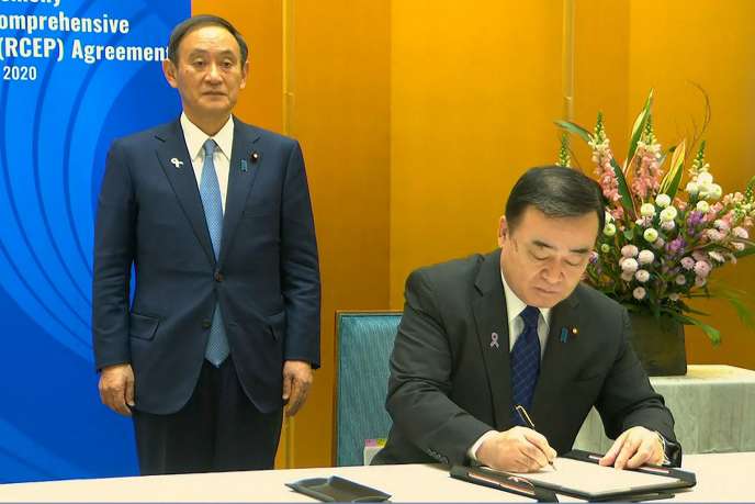 Le ministre de l’économie et de l’industrie japonais, Hiroshi Kajiyama (à droite) et le premier ministre, Yoshihide Suga, à Hanoi, le 15 novembre, lors de la signature du partenariat économique régional global.