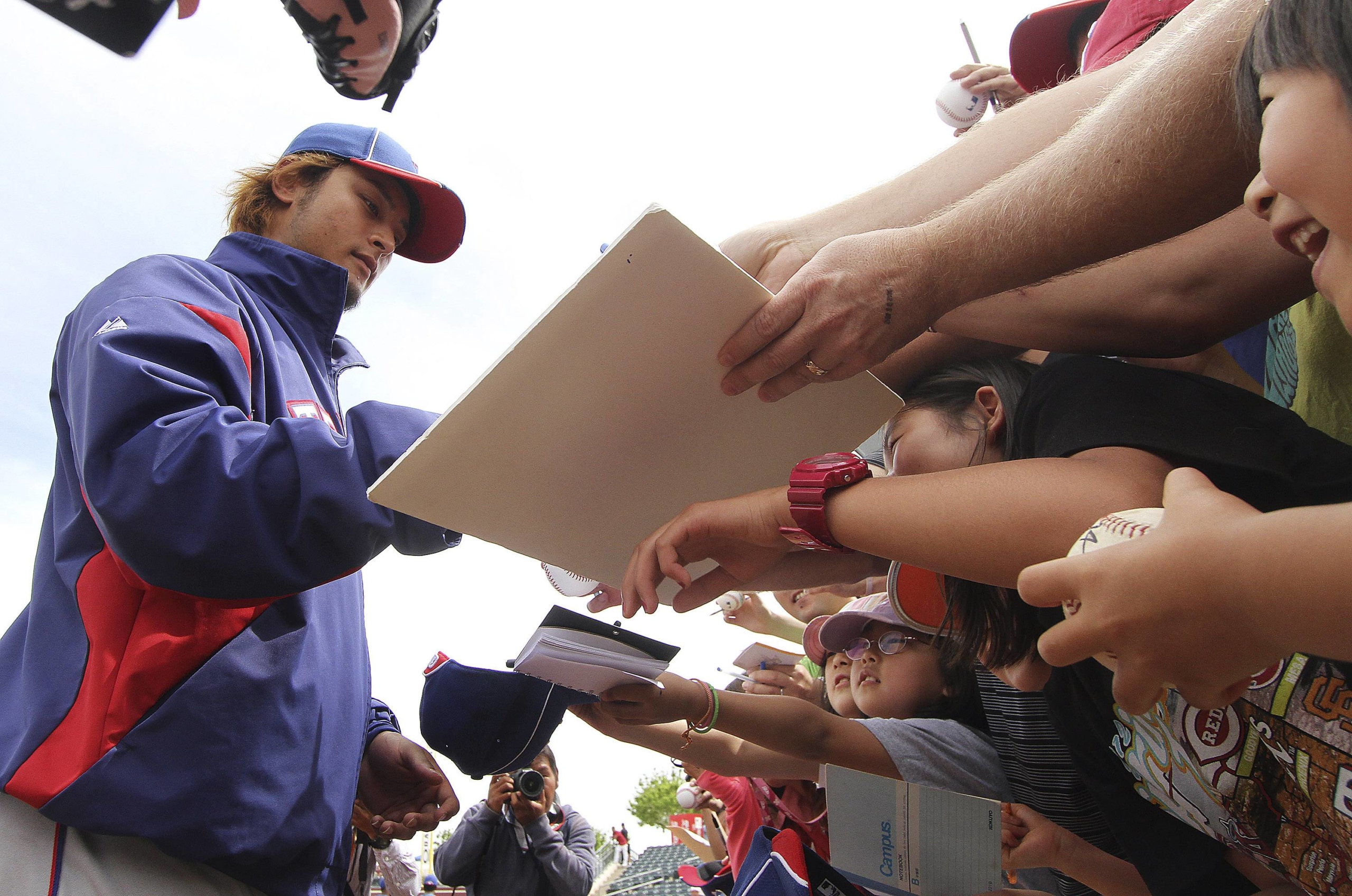 Yu Darvish signs autographs after a spring training session in Surprise, Arizona, on March 25, 2012. | REUTERS