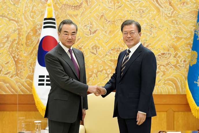 Le ministre des affaires étrangères chinois, Wang Yi (à gauche), sert la main du président sud-coréen, Moo Jae-in, à la Maison Bleue, la demaure présidentielle, à Séoul, le 26 novembre.