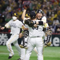 Hawks catcher Takuya Kai leaps into the arms of pitcher Yuito Mori, after the final out of the Japan Series at PayPay Dome in Fukuoka on Nov. 25. | KYODO