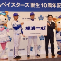 BayStars president Shingo Okamura (second from right), new manager Daisuke Miura (center) and pitcher Shota Imanaga (second from left) present the team's 2021 slogan during a Tuesday news conference in Yokohama. | KAZ NAGATSUKA