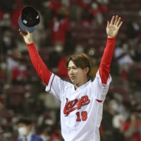 Carp pitcher Masato Morishita waves to fans after the team's win over Hanshin on Tuesday in Hiroshima. | KYODO