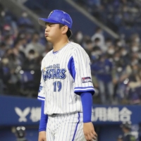 BayStars reliever Yasuaki Yamasaki walks back to the bench after the eighth inning against the Swallows on Tuesday at Yokohama Stadium. | KYODO