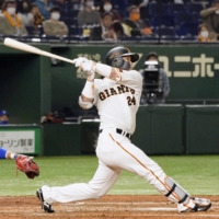 Giants catcher Takumi Oshiro connects on a three-run home run against the BayStars during the third inning at Tokyo Dome on Friday night. | KYODO