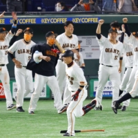The Giants' Yoshiyuki Kamei begins to round the bases as his teammates celebrate after his walk-off home run on Friday at Tokyo Dome. | KYODO
