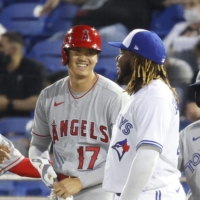 The Angels' Shohei Ohtani talks with Blue Jays first basemen Vladimir Guerrero Jr. after a single during the seventh inning of their game on Thursday. | USA TODAY / VIA REUTERS