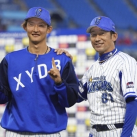 BayStars Daisuke Miura (right) and starting pitcher Kosuke Sakaguchi pose after a win over the Carp in Yokohama on Sunday. | KYODO