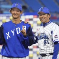 BayStars Daisuke Miura (right) and starting pitcher Kosuke Sakaguchi pose after a win over the Carp in Yokohama on Sunday. | KYODO