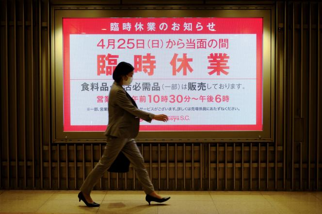 Devant un avis de fermeture temporaire d’un grand magasin à Tokyo, le 26 avril 2021. Le Japon a imposé un nouvel état d’urgence dans la capitale ainsi que dans les départements de l’ouest du pays, Osaka, Kyoto et Hyogo, du 25 avril au 11 mai.