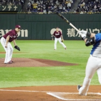 The Fighters' Sho Nakata hits a two-run home run against Eagles starter Masahiro Tanaka during the first inning on Saturday. | KYODO