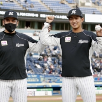 Marines pitcher Fumiya Motomae (right) celebrates with manager Tadahito Iguchi after recording the first win of his career in Chiba on Thursday. | KYODO