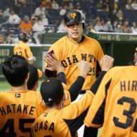 Kazuma Okamoto returns to the Yomiuri dugout after hitting a home run against the Tigers during the fourth inning on Wednesday. | KYODO