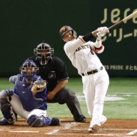 Giants shortstop Hayato Sakamoto hits a two-run double against the Dragons during the third inning at Tokyo Dome on Wednesday. | KYODO