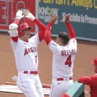 The Angels' Shohei Ohtani celebrates with teammate Jose Iglesias after hitting a home run against the Rangers during the third inning on Wednesday in Anaheim, California. | KYODO