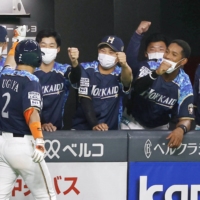 Fighters players congratulate Kenshi Sugiya following his solo home run in the third inning at Sapporo Dome on Friday. | KYODO
