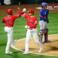 Angels designated hitter Shohei Ohtani (right) is greeted by left fielder Justin Upton after hitting his 15th home run of the season on Tuesday against the Rangers in Anaheim, California. | USA TODAY / VIA REUTERS