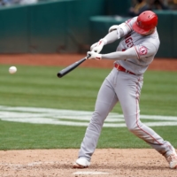 Angels designated hitter Shohei Ohtani hits a seventh-inning single against the Athletics on Saturday in Oakland, California. | USA TODAY / VIA REUTERS